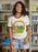 Young girl wearing a t-shirt with a colorful graphic design in a library setting