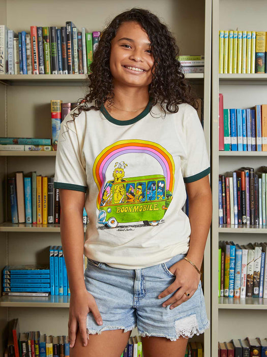 Young girl wearing a t-shirt with a colorful graphic design in a library setting