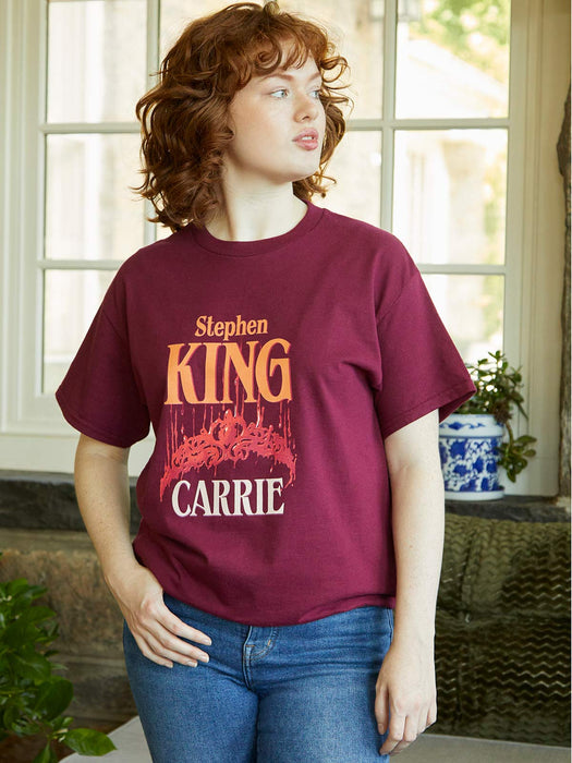 Person wearing a maroon t-shirt with 'Stephen King Carrie' design.