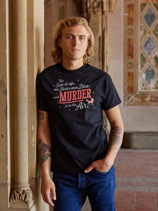 Person wearing a black t-shirt with a humorous graphic and text, standing indoors.