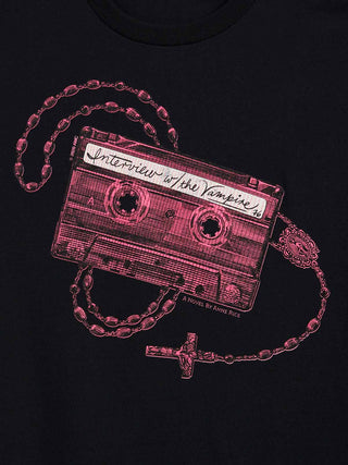 A close-up of a black t-shirt featuring a graphic print of a cassette tape with a rosary with a cross, with the tape label reading 'Interview with the Vampire'.