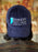 Navy blue cap with 'Hawkins Public Library' logo worn by a person, blurred background