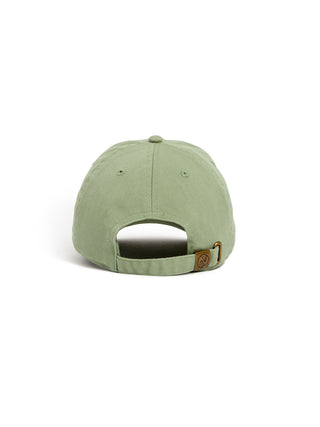 A green baseball cap shown from the back, featuring a fabric strap with a small brown metal brand patch.