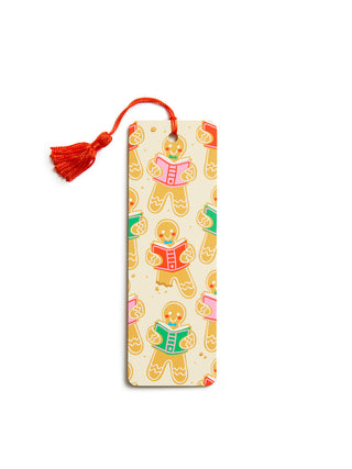 A rectangular bookmark with a tassel, featuring a repeating pattern of gingerbread cookies reading books on a cream background.