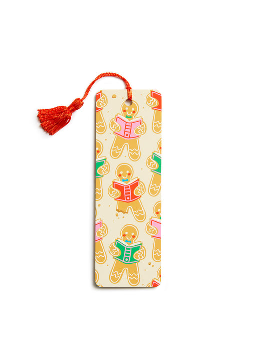 A rectangular bookmark with a tassel, featuring a repeating pattern of gingerbread cookies reading books on a cream background.