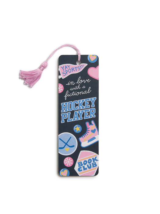 A dark navy book club bookmark with a pink tassel, decorated with colorful hockey-themed stickers and text including 'YAY SPORTS!', 'in love with a fictional HOCKEY PLAYER', and 'BOOK CLUB'.