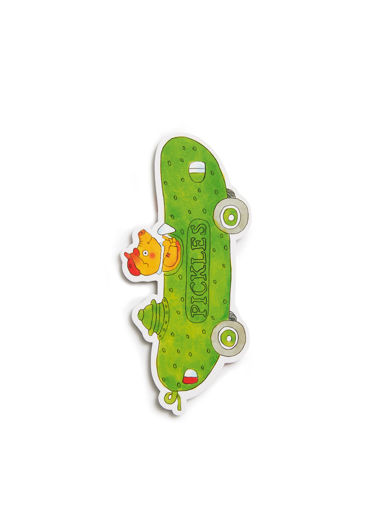 A bookmark shaped like a green pickle, featuring a pig peeking out from the side and the word 'PICKLES' printed vertically. The bookmark has a white border and is shown on a plain white background.