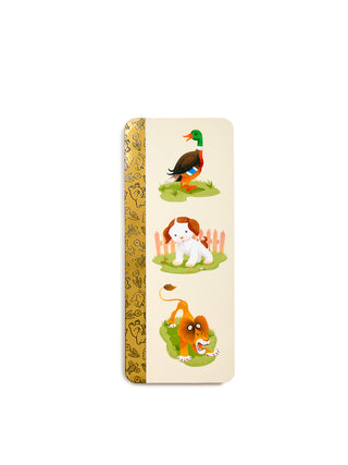 A vertical rectangular bookmark with rounded corners, featuring a cream background and a gold patterned spine. The front displays three cartoon animal illustrations: a green-headed duck on grass, a white and brown dog in front of a fence, and a lion sitting on green grass.