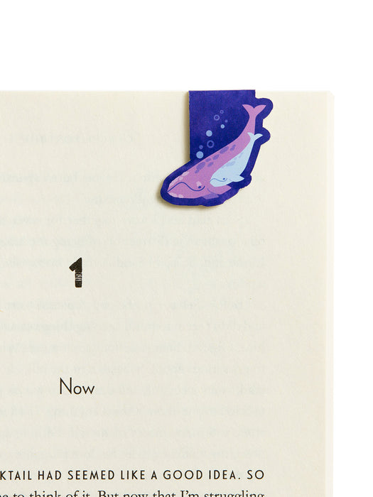 Colorful whale-shaped bookmark on a beige background with text.