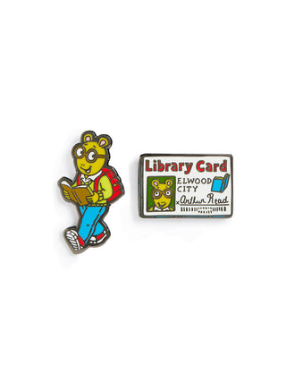 Pin with cartoon character Arthur holding a book and a library card on a white background