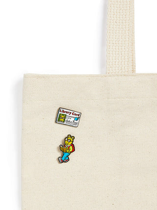 Tote bag with a colorful Arthur pin and library card pin on a white background