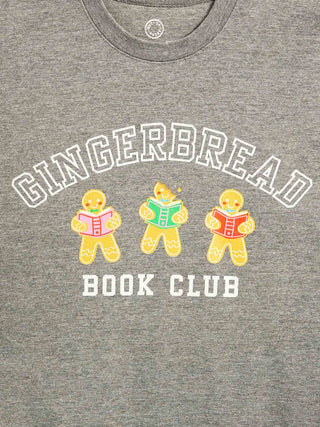 Close-up of a heather gray crewneck t-shirt featuring a graphic print of three gingerbread cookies reading books with the words 'GINGERBREAD BOOK CLUB' in white.