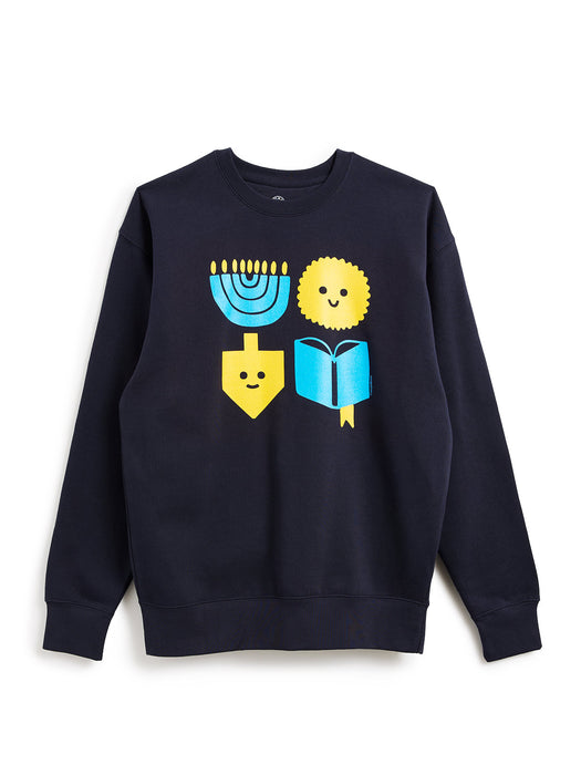 A navy blue crewneck sweatshirt featuring a colorful graphic print of four festive symbols: a blue menorah, a yellow dreidel with a smiley face, a yellow latke with a smiley face, and a blue open book.