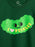 A close-up of a dark green sweatshirt featuring a cartoon pickle graphic with the text 'I [heart] PICKLES' in yellow and a pink heart.