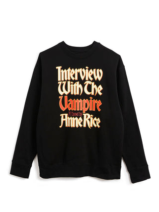 A black crewneck sweatshirt featuring a stylized graphic text print on the front that reads 'Interview With The Vampire' in a gothic font, with 'A Novel By Anne Rice' in orange-red lettering.