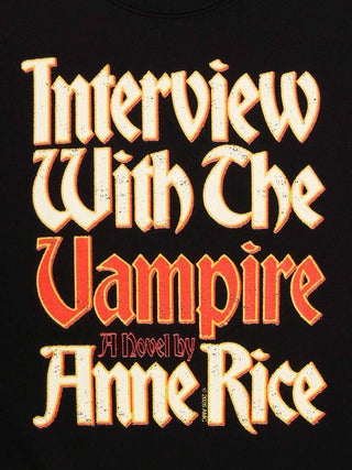 A close-up of a black book cover featuring the title 'Interview With The Vampire' in large distressed cream and red gothic lettering, with 'A Novel by Anne Rice' below in smaller red text.