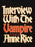 A close-up of a black book cover featuring the title 'Interview With The Vampire' in large distressed cream and red gothic lettering, with 'A Novel by Anne Rice' below in smaller red text.