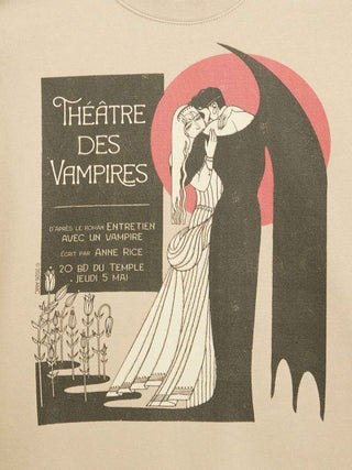 A vintage-style illustrated graphic on a cream background, featuring a vampire in a long black cape with a large pink-red circular backdrop behind it, kissing a woman in a white gown. Text on the left reads “Théâtre des Vampires” with additional French text.