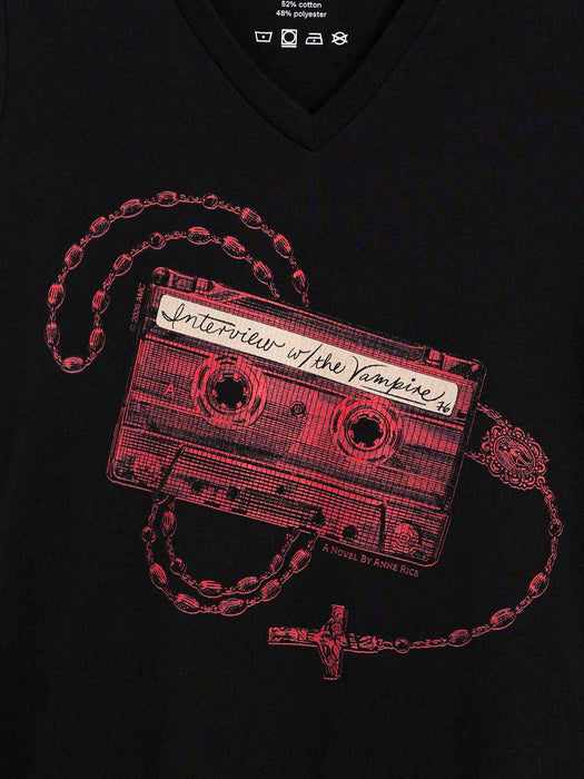 A close-up of a black v-neck t-shirt featuring a graphic print of a red cassette tape necklace with a rosary and cross, with the handwritten text 'Interview w/ the Vampire' on the cassette.