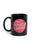 Black mug with pink graphic and text on a white background