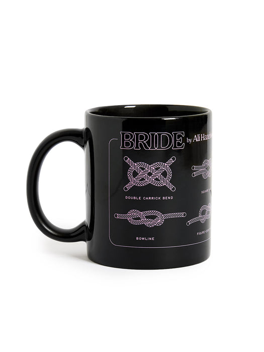 Black mug with white knot designs on a white background