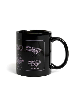 Black mug with white knot designs on a white background