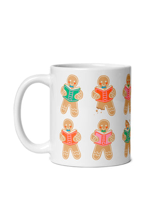 A white ceramic mug featuring a repeating pattern of gingerbread character illustrations reading books, shown against a plain white background.
