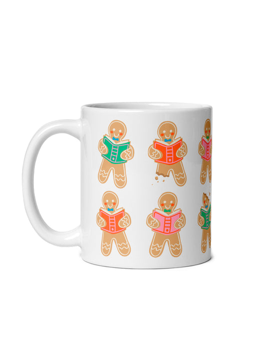 A white ceramic mug featuring a repeating pattern of gingerbread character illustrations reading books, shown against a plain white background.