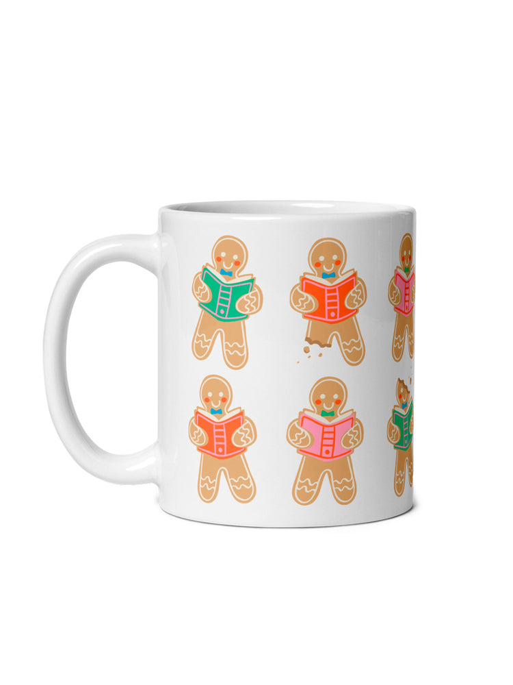 A white ceramic mug featuring a repeating pattern of gingerbread character illustrations reading books, shown against a plain white background.
