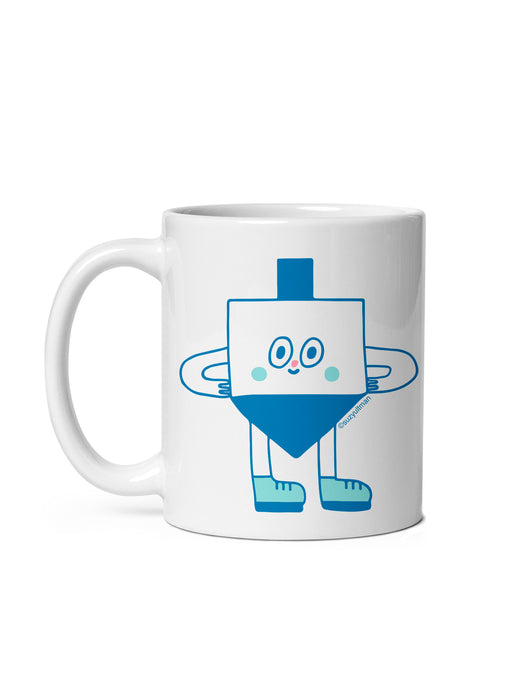 A white ceramic mug featuring a cute blue dreidel character illustration, shown against a plain white background.
