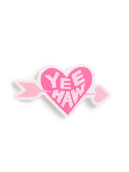 A pink heart-shaped pin with a white border, crossed by a pink arrow, featuring the text 'YEE HAW' in white lettering, set against a plain white background.