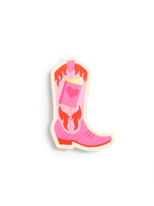 A die-cut sticker shaped like a pink cowboy boot with red flame-like details and a pink pocket holding a book with a heart, shown on a plain white background.