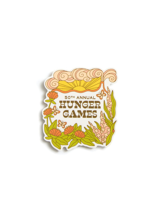 A sticker featuring the text '50th Annual Hunger Games' in brown lettering, surrounded by illustrated orange flowers, green leaves, and a yellow sun on a white background.