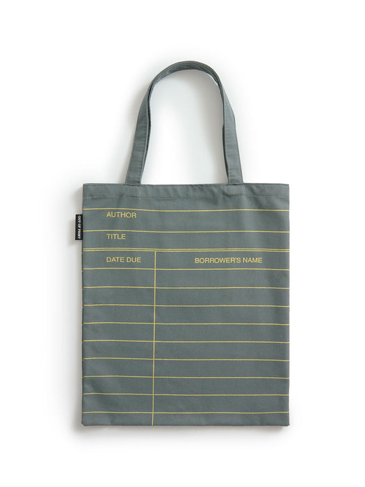 A slate gray canvas tote bag with gold horizontal lines and printed fields for author, title, date due, and borrower's name, shown against a plain white background.