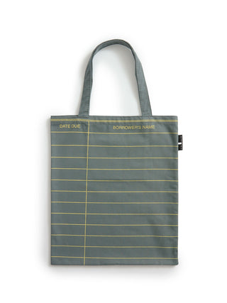 A slate gray fabric tote bag with gold horizontal lines resembling a ledger page, featuring gold text reading 'DATE DUE' and 'BORROWER'S NAME' on the top border, set against a plain white background.