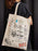 Person holding a tote bag with 'Stranger Things' designs and text.