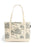 A canvas tote bag with a cream-colored base and a detailed toile-style print featuring castles, trees, and flying dragons in muted gray, blue, and gold tones. The bag has two long cream handles and a small black brand tag on the right side.