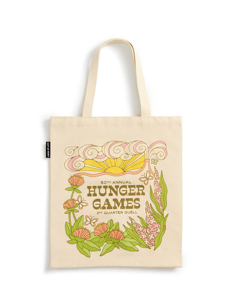 A cream-colored canvas tote bag with long handles, featuring a colorful retro-style graphic for the '50th Annual Hunger Games 2nd Quarter Quell' with a sun, flowers, and leaves, shown on a plain white background.