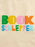 A close-up of a beige fabric surface with the words 'BOOK SCHLEPPER' printed in large, colorful block letters. The letters are filled with green, yellow, pink, orange, blue, and light blue colors.