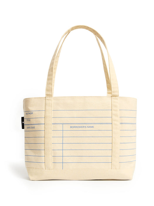 A cream-colored canvas tote bag with blue lined notebook-style writing guides and two shoulder straps, shown on a plain white background.