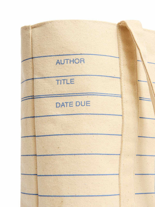 A close-up of a beige canvas tote bag printed with blue horizontal lines and the words 'AUTHOR', 'TITLE', and 'DATE DUE' on the side, shown against a white background.