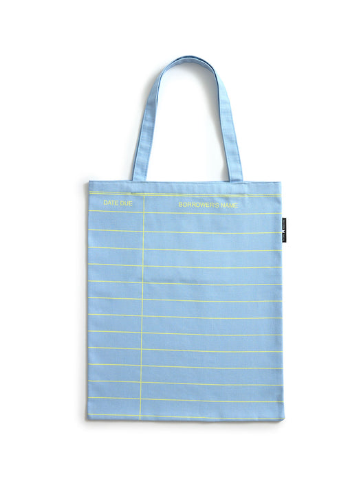 A light cloud blue canvas tote bag with yellow grid lines and text, featuring two shoulder straps, photographed against a plain white background.