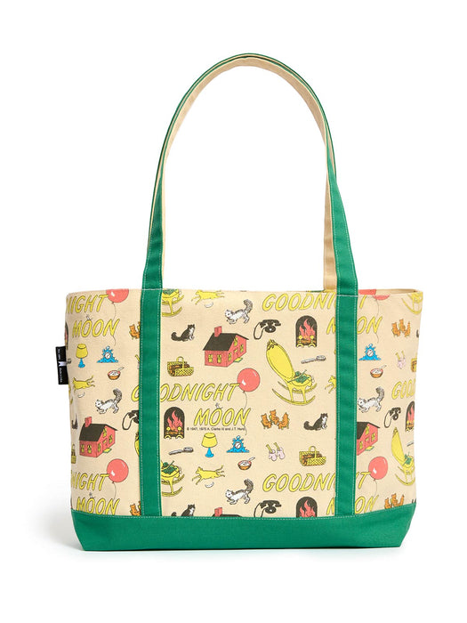 A canvas tote bag with green handles and bottom trim, featuring a cream-colored body printed with a whimsical 'Goodnight Moon' pattern of stars, moons, houses, and animals.