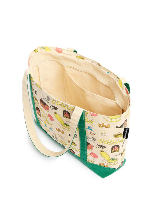 A canvas tote bag with a cream-colored exterior printed with colorful illustrations repeatedly, featuring green fabric trim and handles, shown open against a white background.