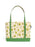 A canvas tote bag with a light beige background printed with green frogs and small white flowers, featuring solid green handles and a green bottom base.