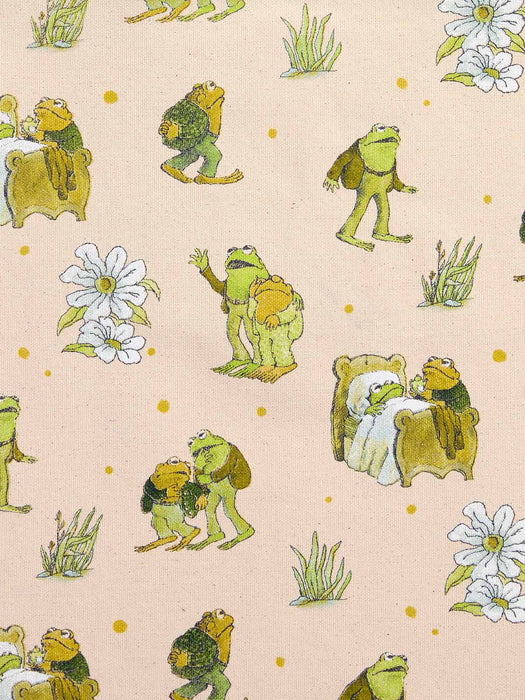 A repeating pattern of whimsical illustrated frogs in green and yellow tones, white flowers, and small grassy tufts on a warm beige background.