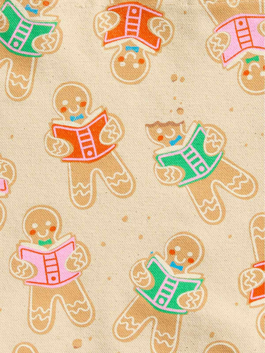 Beige fabric with a repeating pattern of gingerbread cookies reading colorful books in pink, green, and orange.