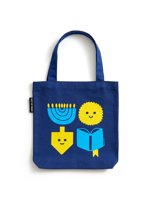 A navy blue canvas mini tote bag with a printed graphic of Hanukkah symbols including a menorah, dreidel, latke, and book, all in bright yellow and blue with simple smiling faces.