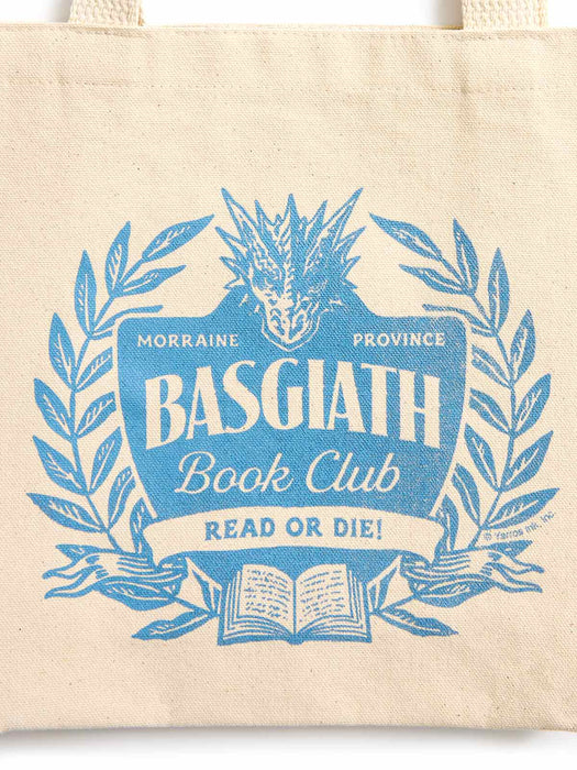 A cream canvas tote bag featuring a blue graphic print of a dragon head, laurel wreath, and an open book with the text 'BASGIATH Book Club' and 'READ OR DIE!'.