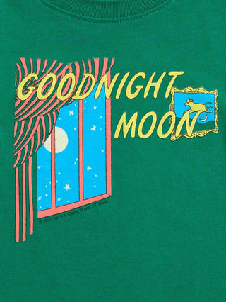 A close-up of a green graphic t-shirt featuring a 'Goodnight Moon' design with a window view of the moon, red-and-white striped curtains, and a yellow moon on a blue night sky.
